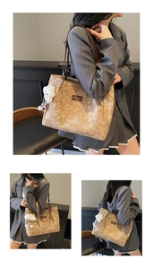 Detail view of large tote bag with floral pattern, leather logo, and plush cloud charm