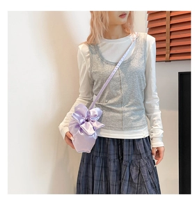 Détail d'un sac à fleurs en satin lavande avec un design plissé et noeud délicat