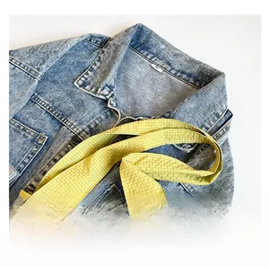 Détail du sac cabas en toile à carreaux jaunes avec anses confortables sur jean