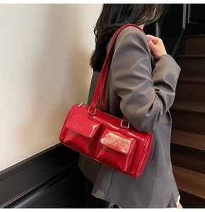 Detail of red patent leather shoulder bag with utility pockets and silver zipper