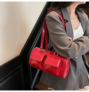 Detail of red patent leather shoulder bag with dual flap pockets and glossy finish