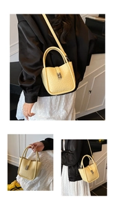 Detail of yellow mini bucket bag with litchi texture and elegant silver metal buckle