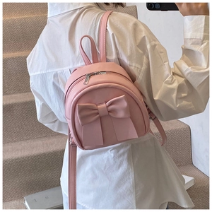 Pink PU leather mini backpack with 3D bow decoration shown on model's back