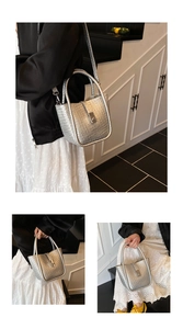 Close-up of silver woven bucket bag with metal buckle and long crossbody shoulder strap