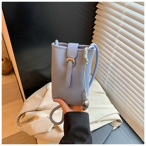 Détail d'un sac téléphone en cuir grainé bleu avec boucle argentée et finition cordon