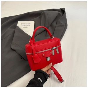 Close-up of red lychee pattern leather vanity bag with silver lock and double zipper
