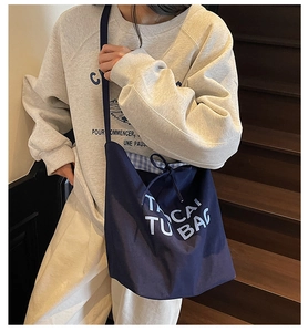 Detail of navy canvas tote bag featuring white TUCAI BAG lettering and drawstring
