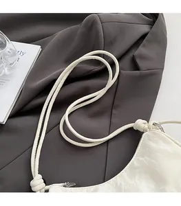 Detail of comfortable knotted shoulder strap and textured white leather commuter bag