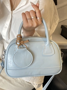 Sac Boston en cuir verni bleu clair avec pendentif décoratif et bandoulière amovible