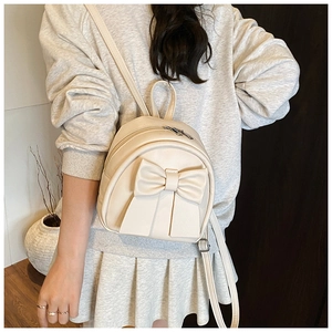 Detailed view of cream PU leather mini backpack featuring a large decorative bow