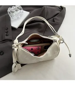Spacious interior of a cream-colored soft leather shoulder bag with daily essentials inside