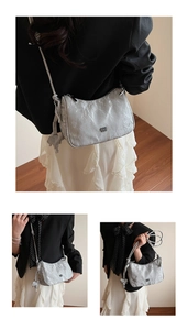 Detail view of silver pleated shoulder bag with metallic logo and elephant charm accessory