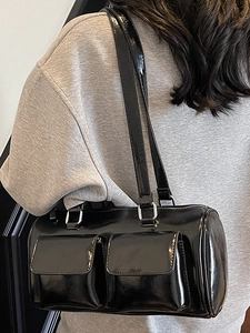 Glossy black cylindrical shoulder bag with double front flap pockets and silver hardware