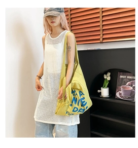 Vue détaillée du débardeur en maille crochetée blanche avec un sac fourre-tout jaune