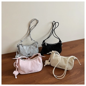 Detail view of ruched dumpling bags in silver, black, pink and beige with elephant charms