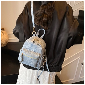 Détail d'un mini sac à dos floral bleu clair avec zips dorés et finitions en tissu