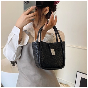 Detail of black woven leather bucket bag featuring elegant silver metal clasp closure