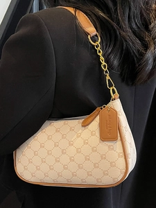 Retro monogram underarm bag with gold chain strap shown on model in black blazer