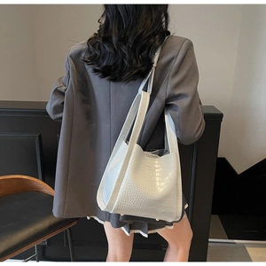 Détail du sac cabas bleu clair à motif crocodile avec larges bretelles et lettres dorées