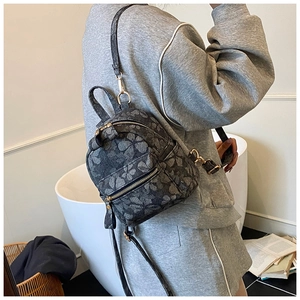Détail du petit sac à dos en jacquard floral avec fermetures éclair dorées