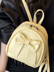 Mini yellow leather backpack for women featuring a large bow and silver zippers