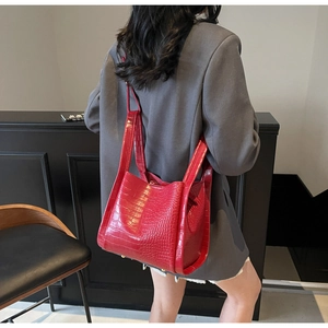 Détail du sac seau rouge à motif crocodile avec rivets de protection métalliques