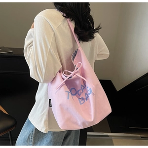 Close-up of pink canvas tote bag with blue lettering and blue checkered fabric lining