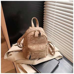 Gros plan d'un mini sac à dos marron à motifs floraux avec fermetures éclair dorées
