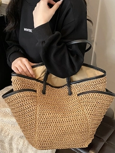 Large straw woven tote bag with black leather trim and handles for beach and casual summer style