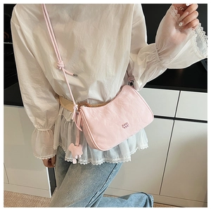 Sac sous le bras rose en forme de croissant avec un ours en peluche sur un modèle
