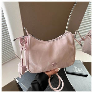 Détail du sac à bandoulière rose texture nuage avec fermeture éclair argentée et logo