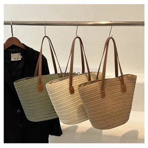 Detailed texture of woven straw tote bags with leather straps in three neutral colors