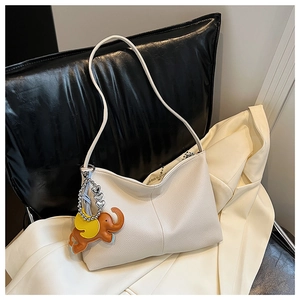 Close-up of beige underarm tote bag with lychee texture and cute brown elephant charm