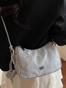 Sac bandoulière argenté plissé avec logo métallique et breloque éléphant élégante