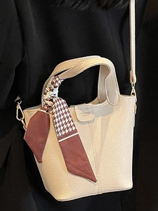 Elegante borsa a secchiello in pelle crema con foulard pied-de-poule e manico da donna