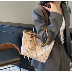 Detail of the high-capacity tote bag featuring reindeer prints and a plush bear charm