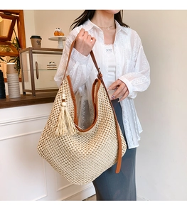 Détail de la texture tissée et de la bandoulière en cuir marron du sac de plage d'été