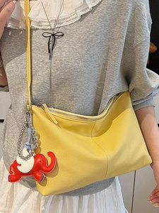 Minimalist yellow pebble leather hobo bag with red elephant charm accessory