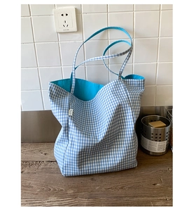 Detail view of the blue and white checkered canvas tote bag with sky blue inner lining