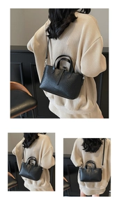 Detail of vintage black crocodile pattern tote bag with top handles and adjustable strap