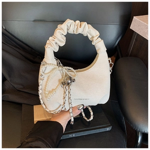 Detail of off-white cloud bag featuring pleated handles and faux pearl chain charm