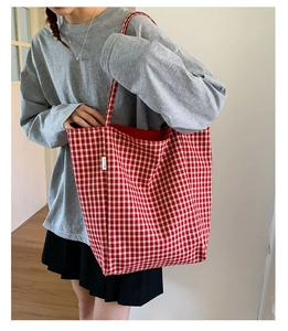 Detail of red and white gingham tote bag showing fabric texture and side label