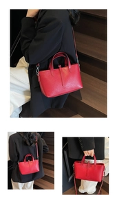 Close-up of red lychee texture leather tote bag with elegant handles and crossbody strap