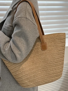 Large capacity straw tote bag with brown leather handles and decorative white stitching