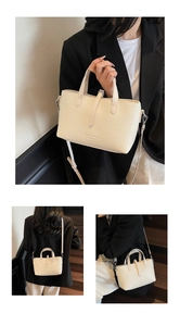 Detail of cream croc-embossed handbag with dual handles and detachable shoulder strap