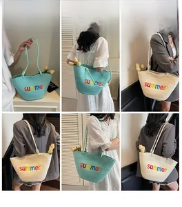 Detail view of large woven beach tote bag with colorful summer embroidery on the front