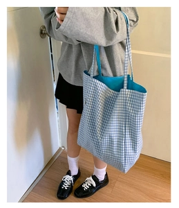 Detail view of large plaid tote bag showing the bright blue lining and canvas material