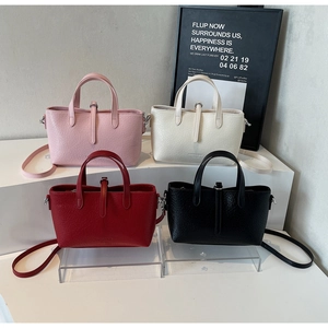 Close-up of four embossed crocodile pattern tote bags in pink, beige, red, and black colors