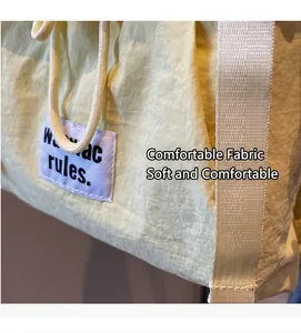 Detail of soft cream fabric and durable woven handle with stylish rectangular label