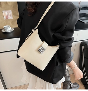Détail du sac à bandoulière beige minimaliste avec bord incurvé et boucle en métal argenté